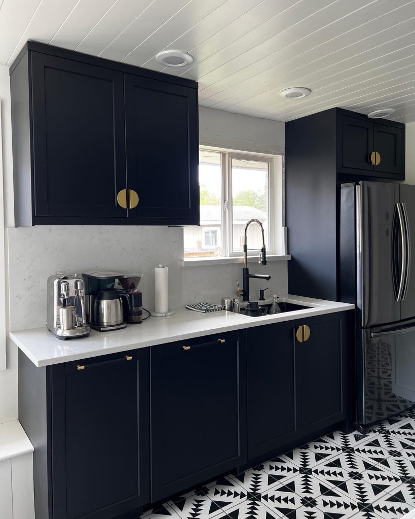 Black and white kitchen with black IKEA lerhyttan cabinets and geometric tile floors